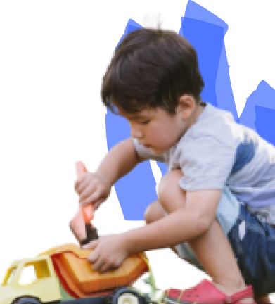 A child is focused on painting a toy construction vehicle with a brush.