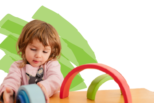 A child plays with colorful wooden arches on a table.