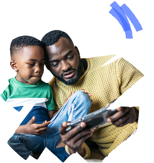 A person and a child are sitting together while looking at a tablet.