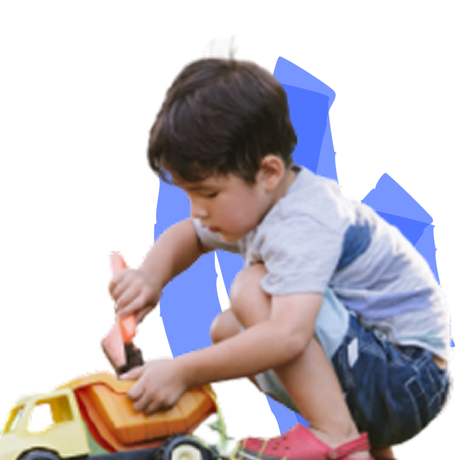 A child is playing with a toy dump truck, focusing intently on the toy.