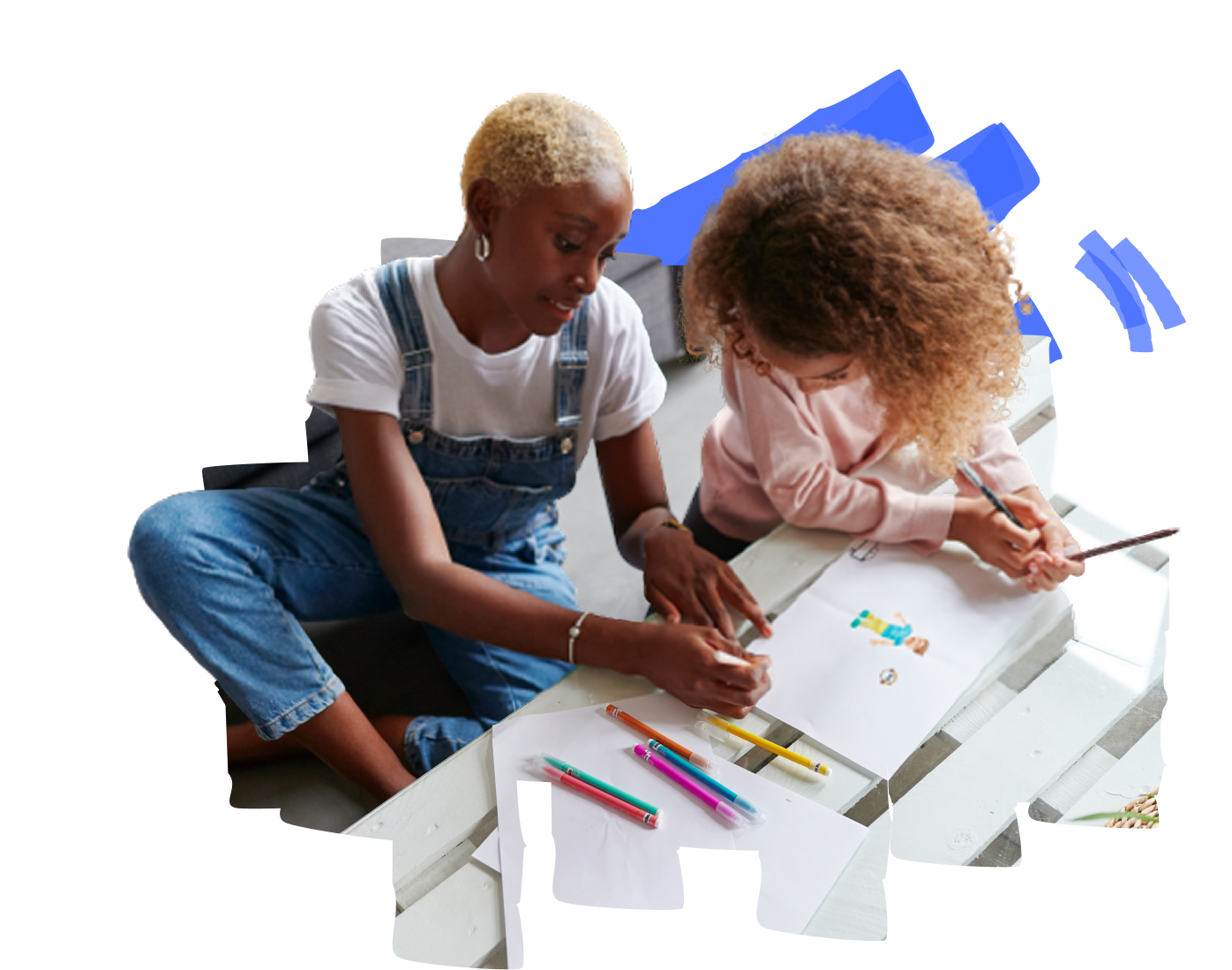 Two people are sitting on the floor, drawing and coloring with various art supplies.