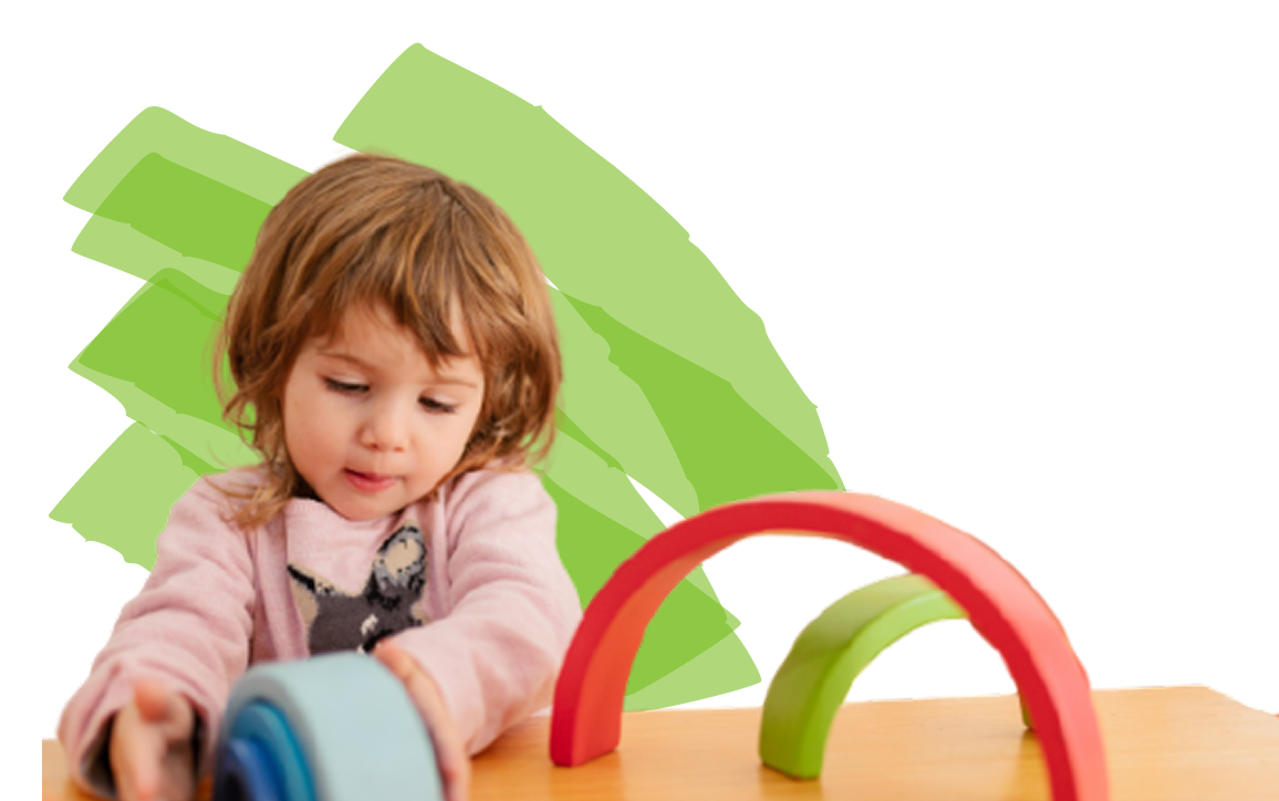 A young child plays with colorful, curved blocks on a wooden surface.